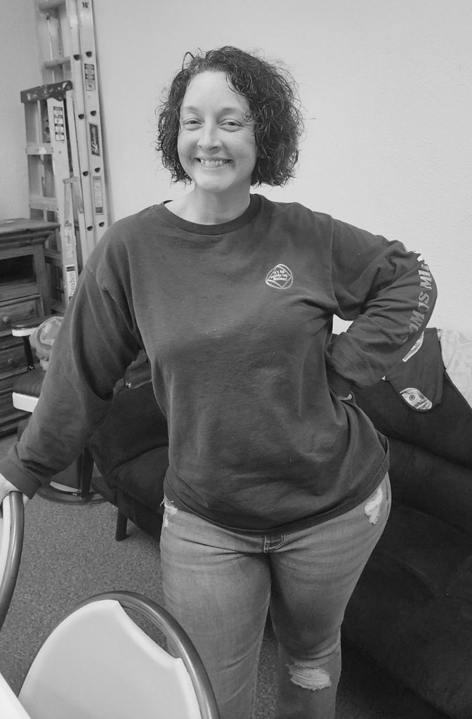 A woman standing in a waiting room in a sweatshirt, before her weight management program
