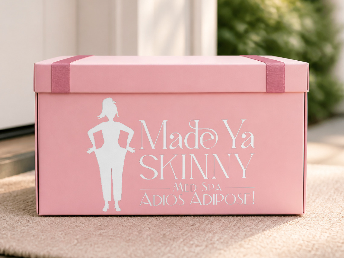 A pink Made Ya Skinny delivery box with the logo printed large on its side, waiting on a front doormat
